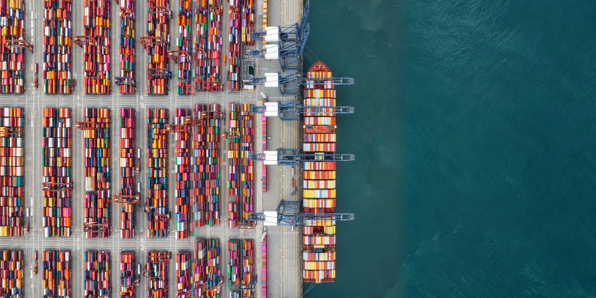 A quay with a loaded ship and container stacks, seen from above